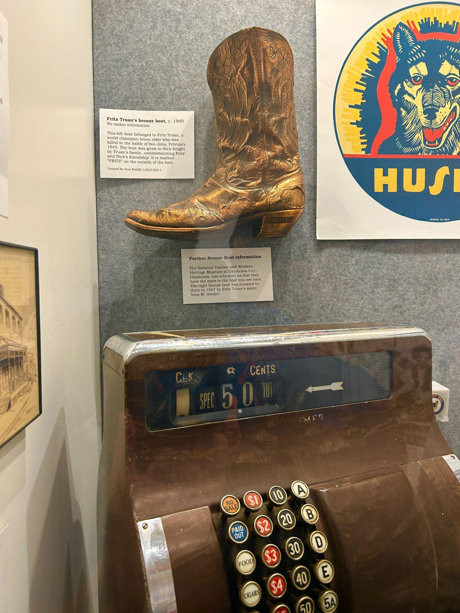 Photo 6 Fritz Truan’s Bronze Boot, and the original cash register for the Bronze Boot Supper Club and Lounge, on display at the Cody Heritage Museum. Photo courtesy of Park County Archives.